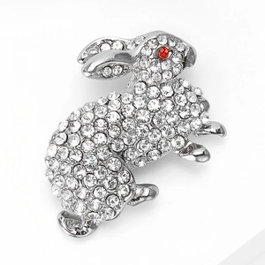 Detail of cute rabbit brooch with shimmering silver crystals and red rhinestone eye