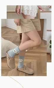 Detail of light blue crew socks featuring cartoon dog embroidery and ruffled lettuce cuffs