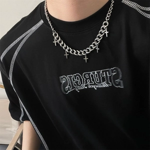 Minimalist silver cross pendant Cuban link chain necklace worn on neck by a model
