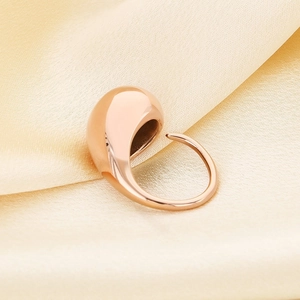 Detail of rose gold teardrop dome ring on luxury champagne silk background texture