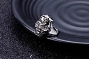 Detailed macro shot of silver skull ring with sparkling crystals on black surface