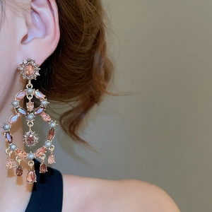 Detail of luxury rose gold earrings with pink teardrop crystals and small white pearls
