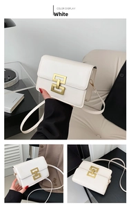 Close-up of elegant white leather crossbody bag with matte gold interlocking clasp detail