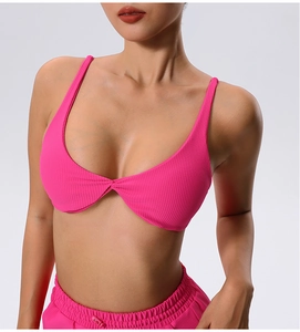 Detail of hot pink ribbed sports bra with knot design and matching high waist shorts