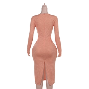 Dettaglio dell'abito midi in maglia rosa con elegante spacco posteriore e trama a coste