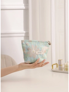 Floral embroidered makeup bag in light blue with flower zipper pull and H&R logo