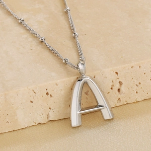 Macro shot of silver-tone polished capital letter A pendant with beaded link chain