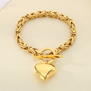 Detailed view of gold stainless steel OT buckle and heart pendant on jewelry set