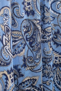 Dettaglio ravvicinato del motivo paisley blu su tessuto leggero in chiffon velato