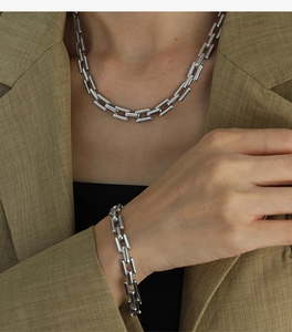 Detail of silver Cuban chain set with minimalist industrial style on male model