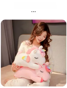 Girl holding rainbow unicorn plush pillows with closed eyes and colorful wings