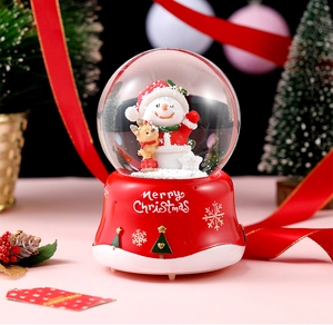 Detail of Christmas crystal ball music box featuring snowman and reindeer figurines