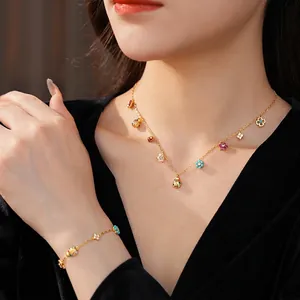 Golden necklace and bracelet set with colorful enamel flower and ladybug charms
