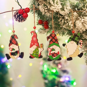 Set of four wooden Christmas gnome ornaments hanging on a pine branch with red berries