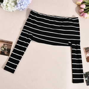Detailed view of striped off-shoulder knit top with soft fabric texture and flower decor