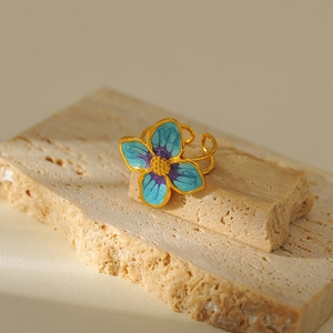 Detail of gold-plated flower ring with blue and purple enamel and adjustable open band