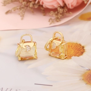 Detail of gold handbag-shaped earrings with champagne crystal and zircon moon