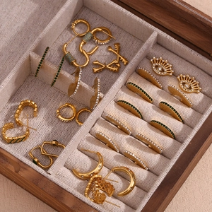 Selection of 18K gold plated C-shaped hollow earrings with green stones in a wooden box