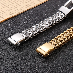 Detail of silver and gold woven metal chains with polished clasps on dark background