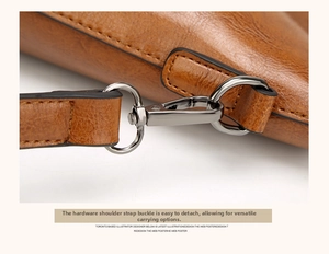 Macro shot of a caramel brown leather bag showing the gunmetal hardware swivel hook