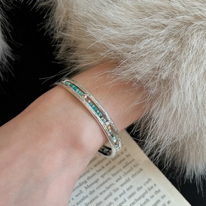 Détail macro du bracelet jonc ethnique en argent avec perles turquoise sur livre vintage