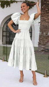 Detail of smocked bust and tiered cake skirt layers on a white summer puff sleeve dress