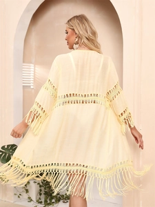 Rear view of beige crochet cardigan with geometric cutouts and long fringe details