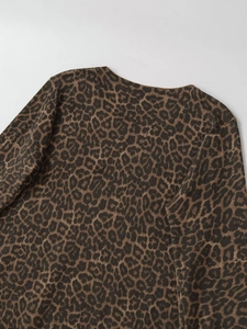 Detailed view of leopard print knit sweater featuring a round neck and soft texture