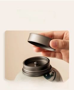 Detail of the airtight alloy lid on a hand-painted celadon ceramic tea canister