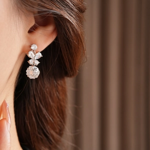 Vue macro d'une boucle d'oreille papillon en argent avec pierres sur l'oreille du mannequin