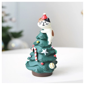 Detail of a resin Christmas tree topper featuring a cute calico cat with a red Santa hat