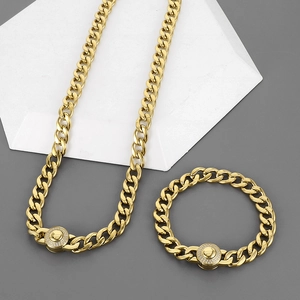 Gros plan sur ensemble collier et bracelet maille gourmette dorée avec fermoirs strass