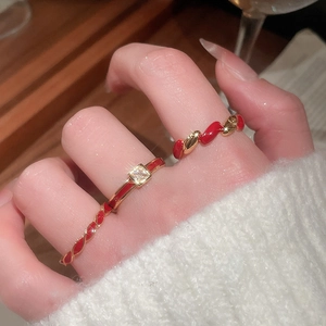 Close-up of gold-plated red enamel ring set with zircon on model's hand