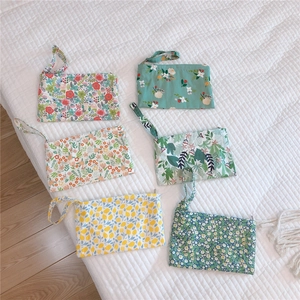 Detailed set of six cotton floral pouches with zip closures and wrist straps shown flat