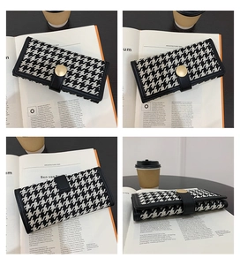 Detail of classic houndstooth long wallet with gold snap button and leather edges