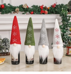 Close-up of knit Christmas gnome wine bottle covers with snowflake embroidery and white beards