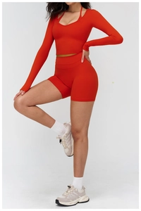 Detail of red brushed yoga set featuring cutout back long sleeve top and high waist shorts