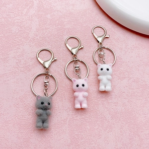 Three-piece set of cute flocked cat keychains in grey, pink and white with metal rings