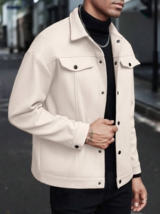 Detailaufnahme der cremefarbenen Wolljacke mit Textur und vorderen Pattentaschen-Details