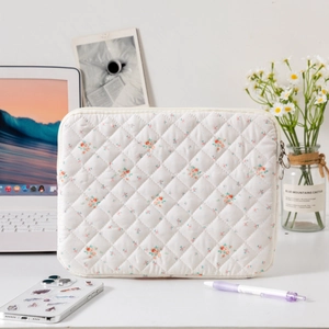Quilted floral laptop sleeve with secure silver zipper closure and soft cotton padding