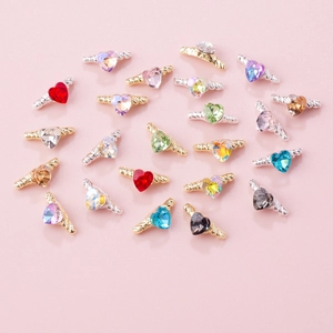 Colorful heart-shaped nail charms with metal wings in various gemstone colors