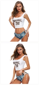 Dettaglio degli shorts in denim blu con lacci laterali e crop top bianco con logo