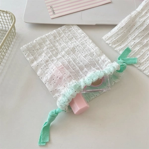 Detail of small polka dot drawstring bag with mint green cords for jewelry storage
