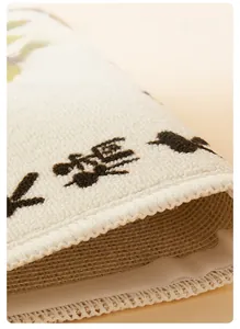 Detail of reinforced edge stitching on a beige sisal cat scratcher mat with black patterns
