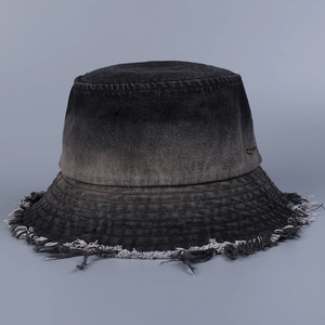 Detail of gradient denim bucket hat with distressed raw edges and a small metal logo tag