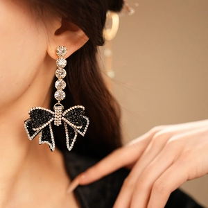 Detailansicht langer glitzernder Blumen Schleifenohrringe mit schwarzen weißen Strass
