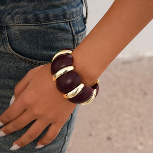 Detail showing high-polish gold and dark purple acrylic links of the bohemian bracelet