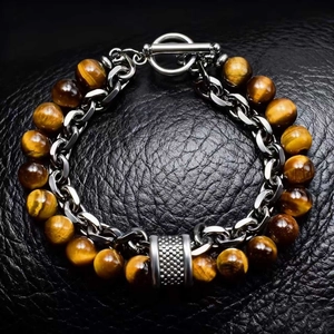 Close-up of men's bracelet with tiger eye beads, silver chain and textured T-bar clasp
