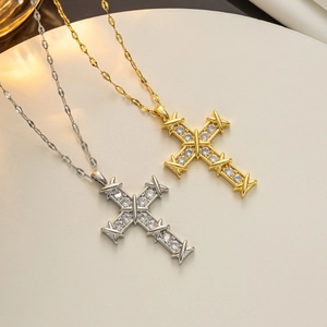 Detail view of gold and silver cross pendants with micro-pave zircons and X-shaped accents