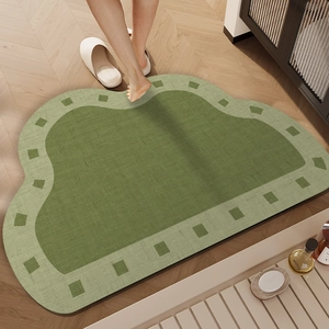 Absorbent green cloud-shaped bath mat with woven texture and light green checkered border